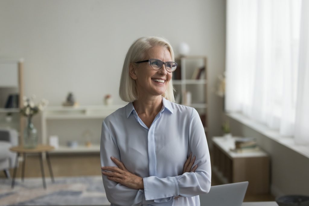 senior business owner stood up in office space