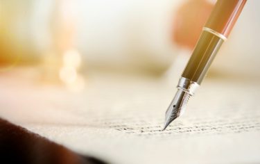 close up of a pen signing paper