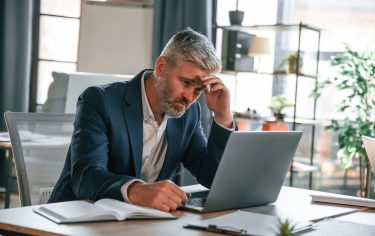 business owner looking stressed sat in front of laptop